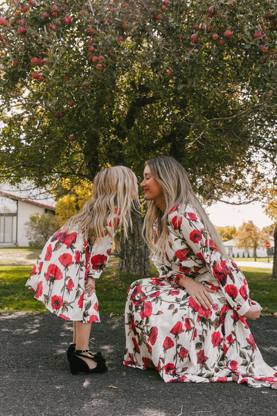 Mother and daughter in matching white dresses with red floral print, V-neck, long sleeves, and tie-waist. - Image 7