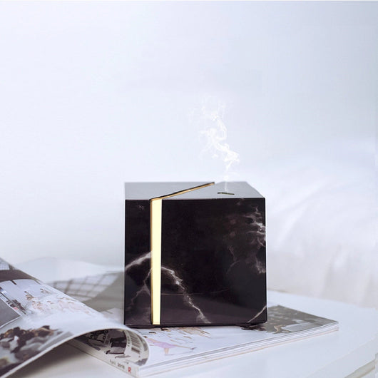 White and grey marble pattern ultrasonic aromatherapy diffuser with a vertical gold LED light strip and power button. - Image 10