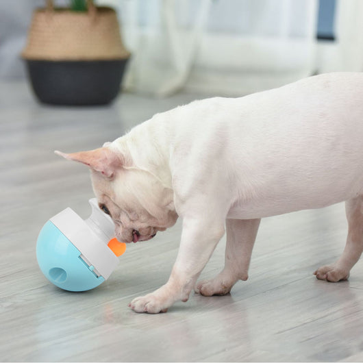 Orange and blue interactive pet food dispenser toy with multiple tiers and white balls, next to its black packaging. - Image 7
