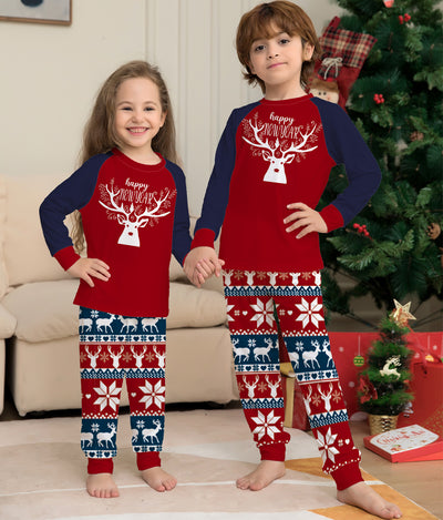 Child wearing a red and navy blue Christmas pajama set with a white reindeer and "happy NEW YEAR" text on the top, and fair isle pattern pants. - Image 6