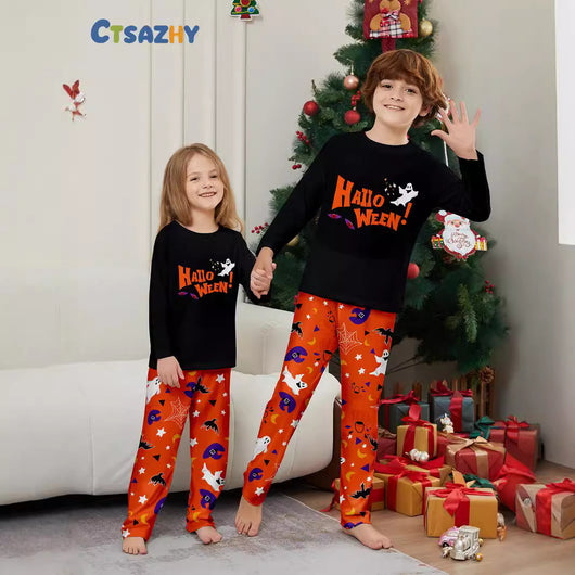 Family of four wearing matching black and orange Halloween long-sleeve pajamas with ghost and bat prints. - Image 3