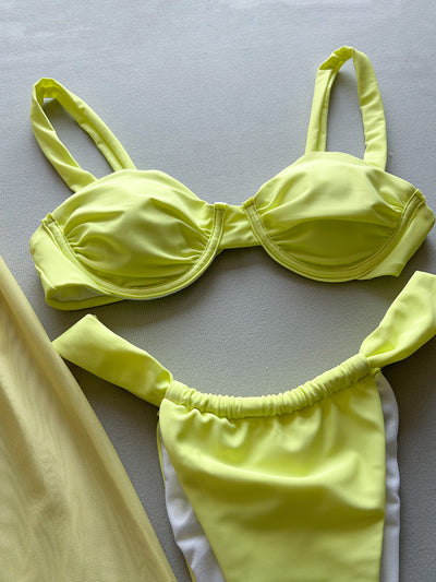 Woman in a light yellow three-piece bikini with an underwire top, matching bottoms, and a sheer floral sarong skirt. - Image 10