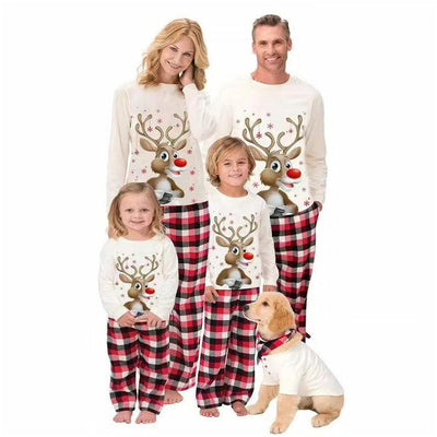 Family of four and a golden retriever wearing matching white long-sleeve reindeer tops and red plaid pajama pants.