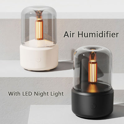 White cylindrical aroma diffuser with a clear top and an amber candlelight-effect LED light. - Image 2