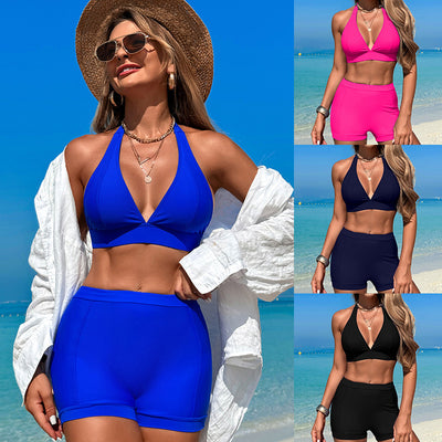 Woman in a hot pink halter neck bikini top and matching high-waisted swim shorts at the beach.