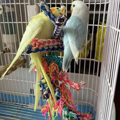 Colorful parrot toy with woven blue, white, and red paper strips, filled with bright crinkly paper, on a wooden background. - Image 6