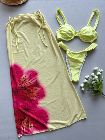 Woman in a light yellow three-piece bikini with an underwire top, matching bottoms, and a sheer floral sarong skirt. - Image 8
