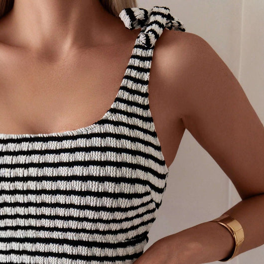 Women's black and white striped two-piece swimsuit with a tube top and high-waisted bottoms, worn by a person lounging on a white bed. - Image 3