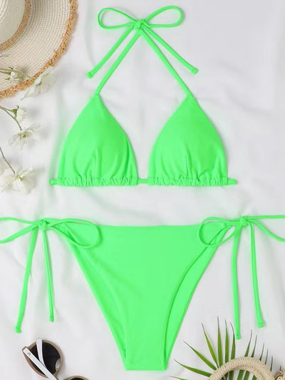 Neon yellow halter bikini with triangle top and tie-side bottoms, displayed on a light wood surface. - Image 17