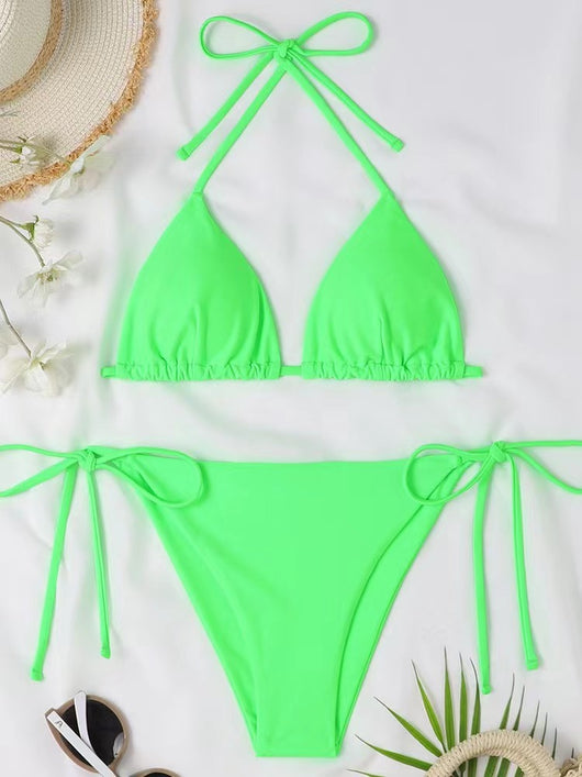 Neon yellow halter bikini with triangle top and tie-side bottoms, displayed on a light wood surface. - Image 17