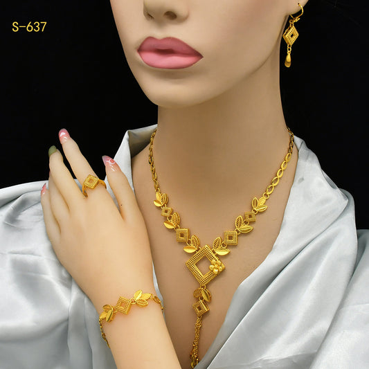 Ornate gold-colored bridal jewelry set with filigree design, including a necklace, drop earrings, bracelet, and ring.