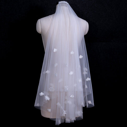 White and ivory sheer fabric swatches for a wedding veil displayed on green grass. - Image 5