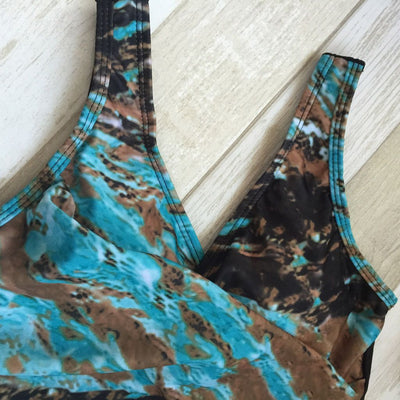 Women's one-piece swimsuit with a black bottom and a blue, brown, and white abstract patterned, ruched V-neck top. - Image 4