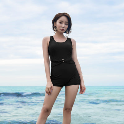 Woman in a mustard yellow one-piece swimsuit with a scalloped waist and short bottoms, standing in the ocean. - Image 11
