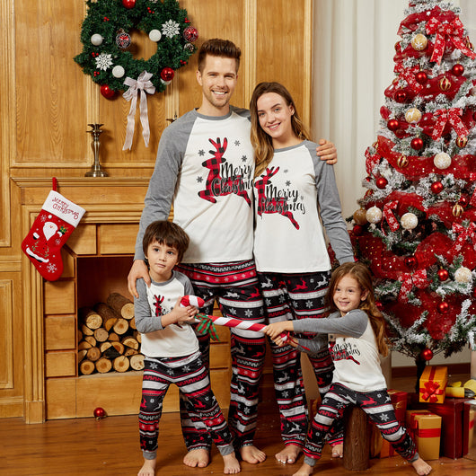 Woman wearing a white and grey long-sleeve Christmas pajama top with a plaid reindeer and patterned holiday pants. - Image 9
