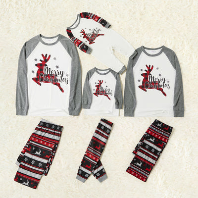 Woman wearing a white and grey long-sleeve Christmas pajama top with a plaid reindeer and patterned holiday pants. - Image 15
