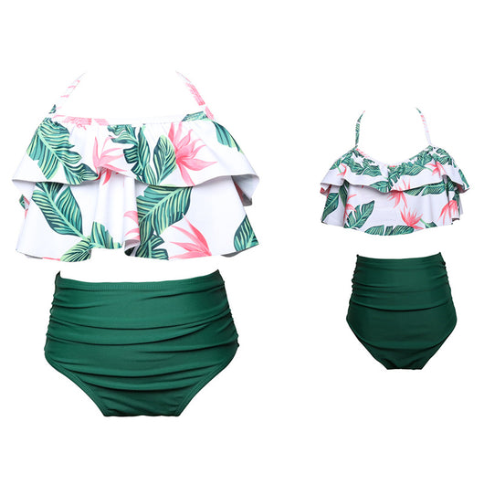 Black wrap bikini top with high-waisted pink and green tropical leaf print swim bottoms.