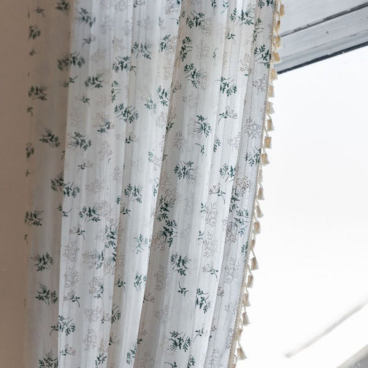 White semi-sheer curtain with green and grey floral pattern and cream tassel trim, hanging in a window. - Image 8