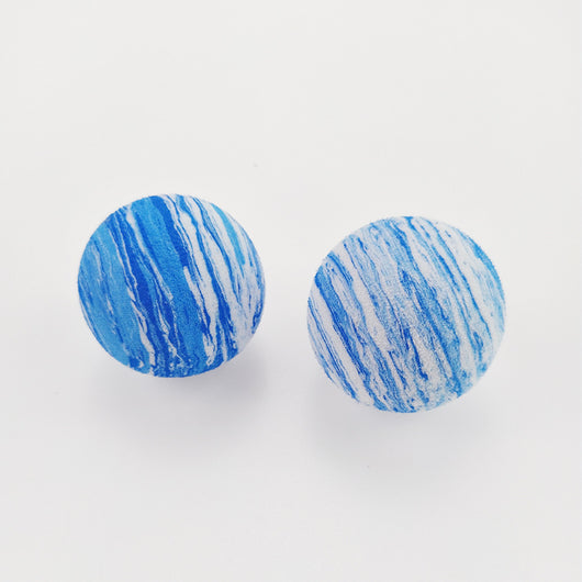 Black and white marbled EVA foam ball, a pet toy, on a white background with blurred flowers. - Image 3