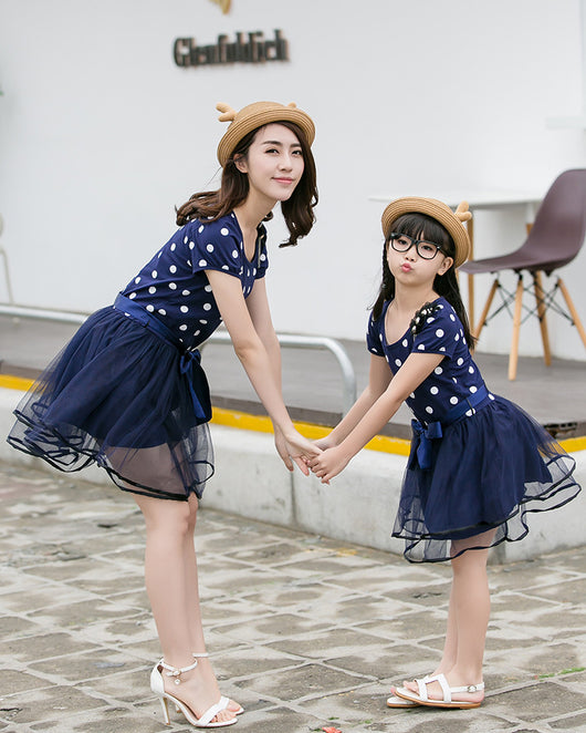 Family of four wearing matching white and black polka dot outfits. Dad and son in t-shirts, mom and daughter in dresses. - Image 11