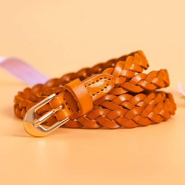 Women's braided brown leather belt with a D-shaped gold-tone pin buckle, coiled on a peach background.