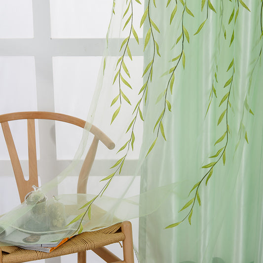 Light green sheer curtains with a delicate willow leaf print, hung on a window rod in a bright room.