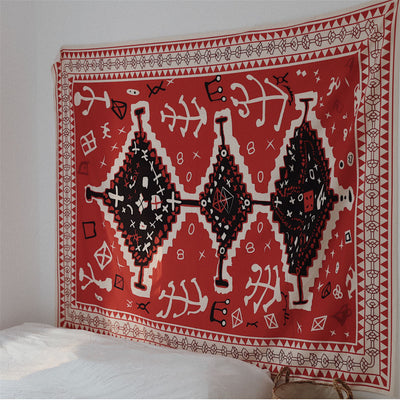 Red tapestry with black and white geometric tribal pattern hanging on a white wall above decorative pillows. - Image 5
