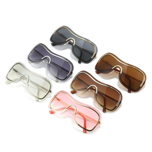 Women's fashionable shield sunglasses with a gold metal frame and dark gray lenses, featuring a unique wavy design.