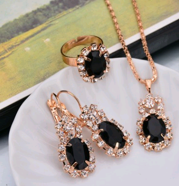Rose gold-toned necklace, earrings, and ring set with large oval clear gemstones surrounded by smaller stones. - Image 4