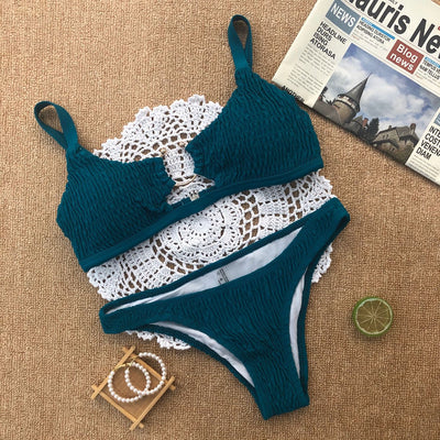 Red pleated cutout bikini set with a triangle top and thong bottom, displayed with yellow sunglasses and white flowers. - Image 6