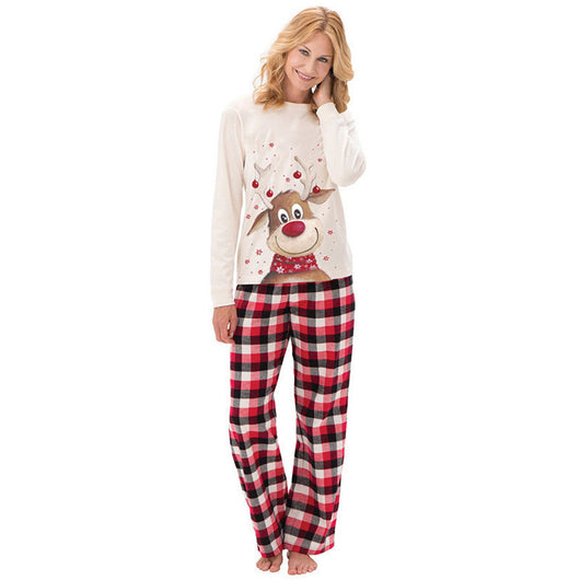 Family of four and a golden retriever puppy wearing matching cream reindeer print and red plaid Christmas pajamas. - Image 2