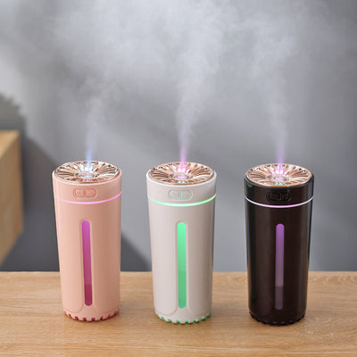 Pink cylindrical USB humidifier with a colorful light diffuser, control buttons, and a single fog outlet.