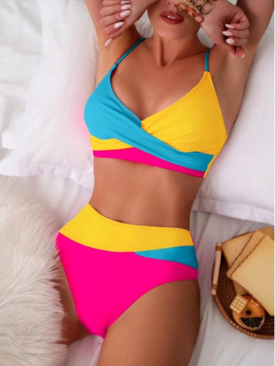Woman wearing a blue color block split swimsuit with a wrapped front bikini top and high-waisted briefs. - Image 9