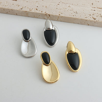 Pair of gold-toned irregular earrings with black onyx-like inserts, featuring a modern, abstract design. - Image 12
