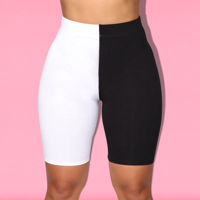 Woman wearing a black and white color-block long-sleeve top and matching shorts with white sneakers. - Image 21
