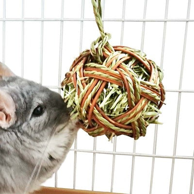 Natural grass woven ball molar stick for chinchillas, rabbits, and guinea pigs, featuring light green and brown strands.