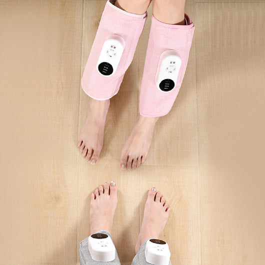Pink automatic air bag heating calf massagers on a person's legs, with white control units visible.