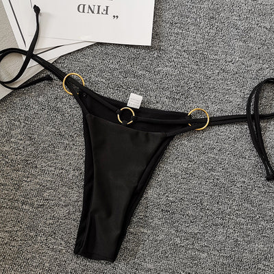Solid black two-piece swimsuit set with a bandeau top, gold-tone O-rings, and tie straps, paired with matching thong bottoms. - Image 10