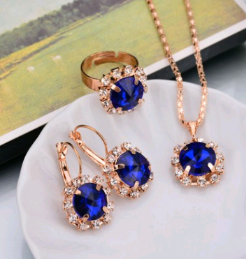Rose gold-toned necklace, earrings, and ring set with large oval clear gemstones surrounded by smaller stones. - Image 21