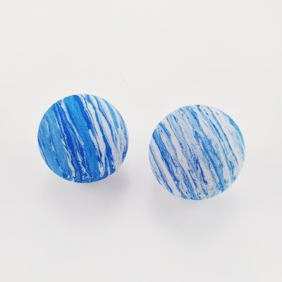 Black and white marbled EVA foam ball, a pet toy, on a white background with blurred flowers. - Image 8