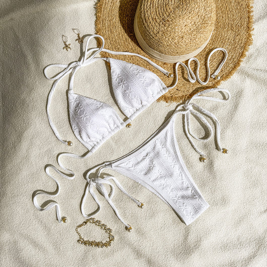 White halter lace-up bikini with a textured pattern, styled with a straw hat and gold jewelry on a sandy background. - Image 9