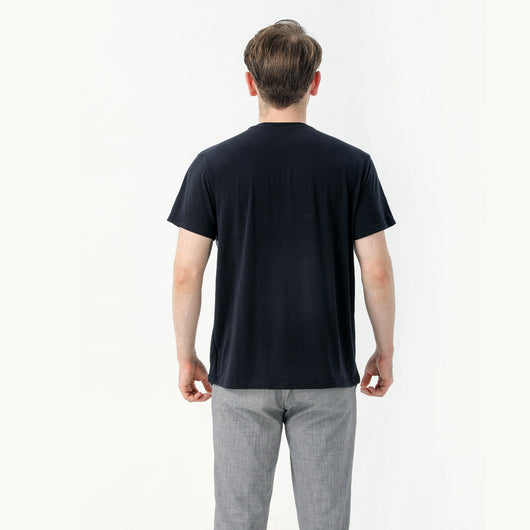 Young boy wearing a white short-sleeve t-shirt with blue tropical leaf print and a black chest pocket. - Image 12