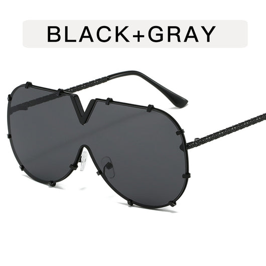 Oversized V-shaped sunglasses with a gold metal frame, white accents, clear lenses, and decorative rivets. - Image 11