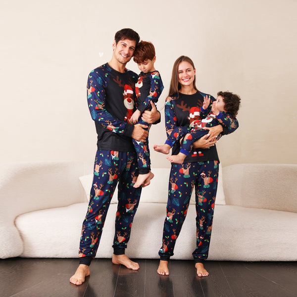 Family Christmas pajamas with a cartoon reindeer wearing a Santa hat and red scarf on a black top, and dark blue pants with a repeating reindeer and holly patte