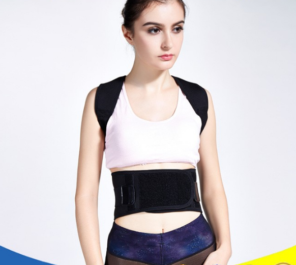 Woman wearing a black posture corrector with shoulder straps and a wide waist belt over a pink sports bra.