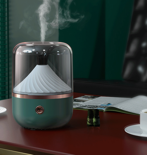 Dark green aromatherapy machine with a transparent top, yellow spiral diffuser, and copper trim.