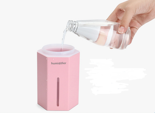Light blue pencil-shaped mini humidifier with wood-grain top and glowing green light, next to a white teacup and pink gift box. - Image 3