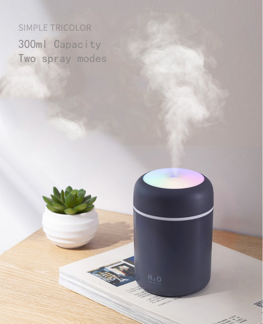 Dark gray ultrasonic aromatherapy essential oil diffuser with a colorful LED light band and rainbow top light. - Image 15