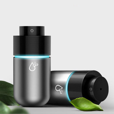 Silver-gray car humidifier and air purifier with a black top, emitting mist and glowing with a blue LED light. - Image 12
