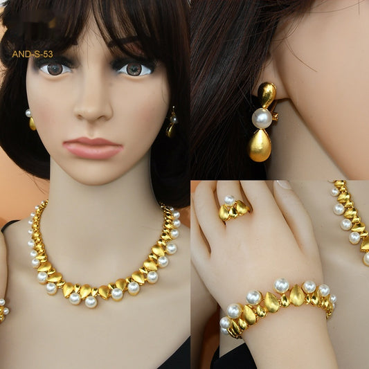Women's four-piece jewelry set with matte gold teardrop links and white pearls, including a necklace, earrings, ring, and bracelet.